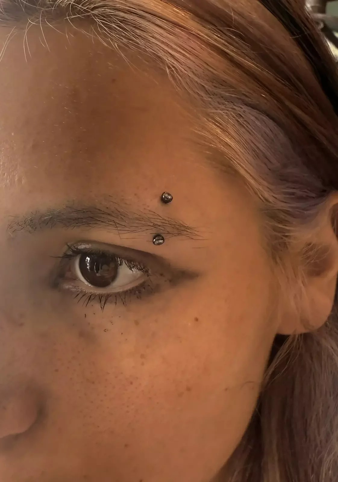 Healed eyebrow piercing with a black PVD curved barbell with internally threaded cubic zirconia ends on the barbell by Amber Paje of James River Tattoo in Carrollton Virginia