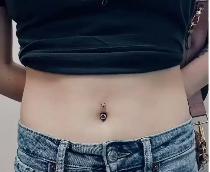 Healed navel piercing with a titanium navel curve with aurora borealis cubic zirconia internally threaded ends done by Amber Paje of James River Tattoo in Carrollton Virginia