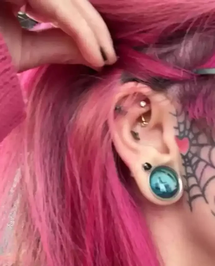 Fresh rook piercing completed using a Gold PVD curved barbell done by Amber Paje of James River Tattoo in Carrollton Virginia
