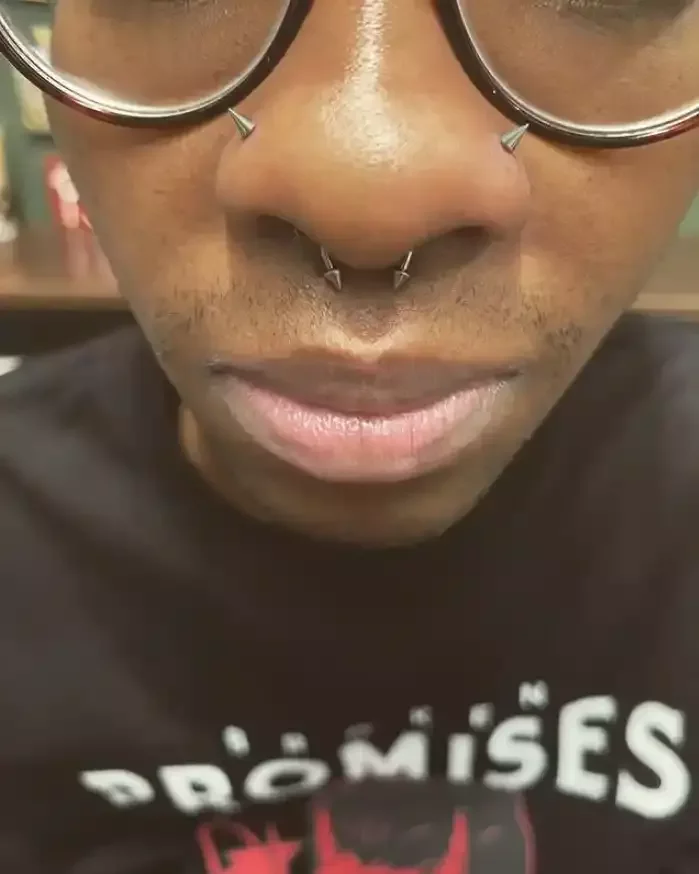 Paired nostril and septum piercings of titanium spike threadless ends and labret posts and circular barbell with internally threaded spike ends by Amber Paje of James River Tattoo in Carrollton VA