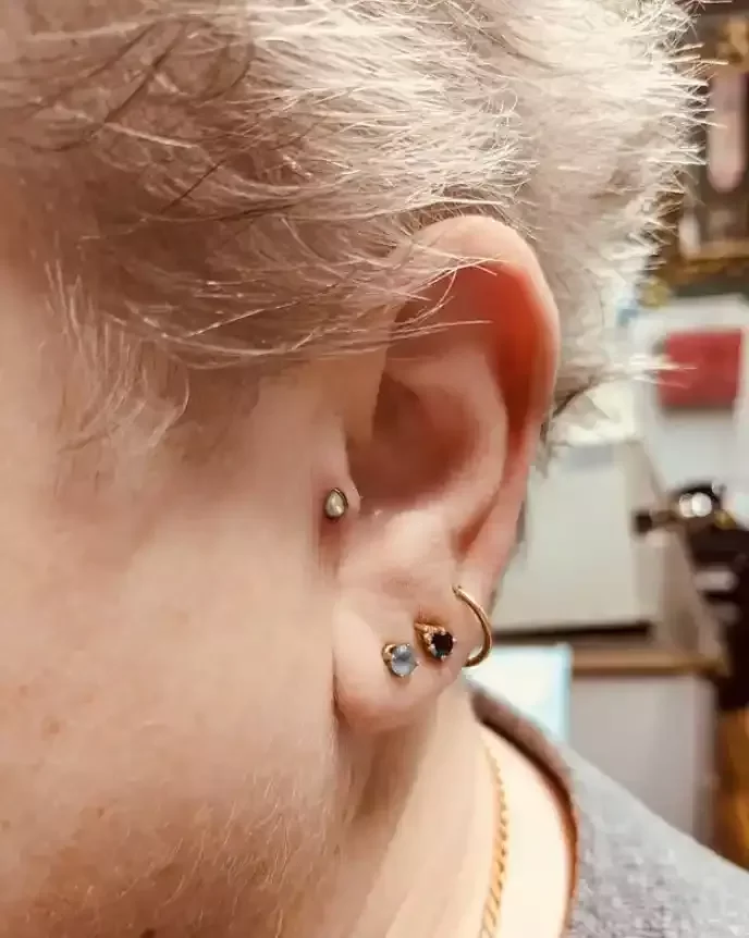 Fresh tragus using titanium internally threaded pear shape opal end and titanium internally threaded labret post done by Amber Paje of James River Tattoo in Carrollton Virginia
