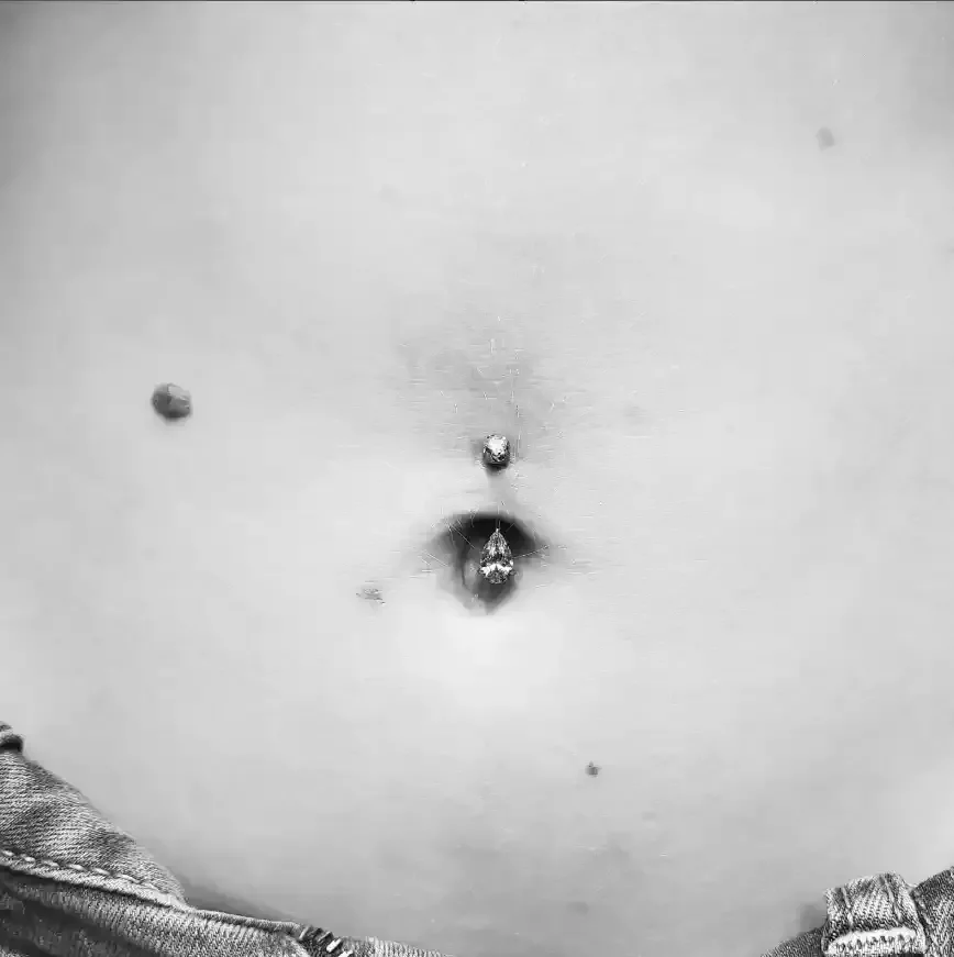 Fresh navel piercing using a titanium internally threaded navel curve with a cubic zirconia and pear shape cubic zirconia ends done by Amber Paje of James River Tattoo in Carrollton Virginia