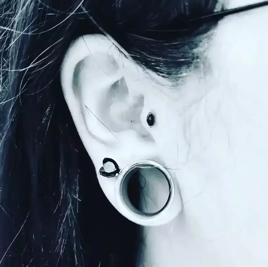 Fresh tragus piercing using titanium internally threaded oval shaped black cubic zirconia end and titanium internally threaded labret post done by Amber Paje of James River Tattoo in Carrollton VA