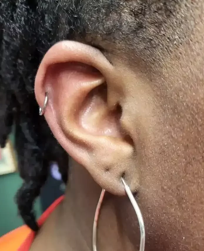 Fresh helix piercing using a titanium clicker hoop done by Amber Paje of James River Tattoo in Carrollton Virginia