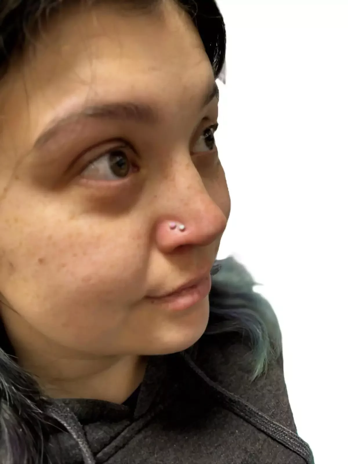 Fresh nostril piercings done using one pink and white opal threadless ends and threadless labret posts done by Amber Paje of James River Tattoo in Carrollton Virginia