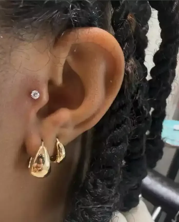 Fresh tragus piercing pierced with a threadless cubic zirconia end and threadless labret post done by Amber Paje of James River Tattoo in Carrollton Virginia